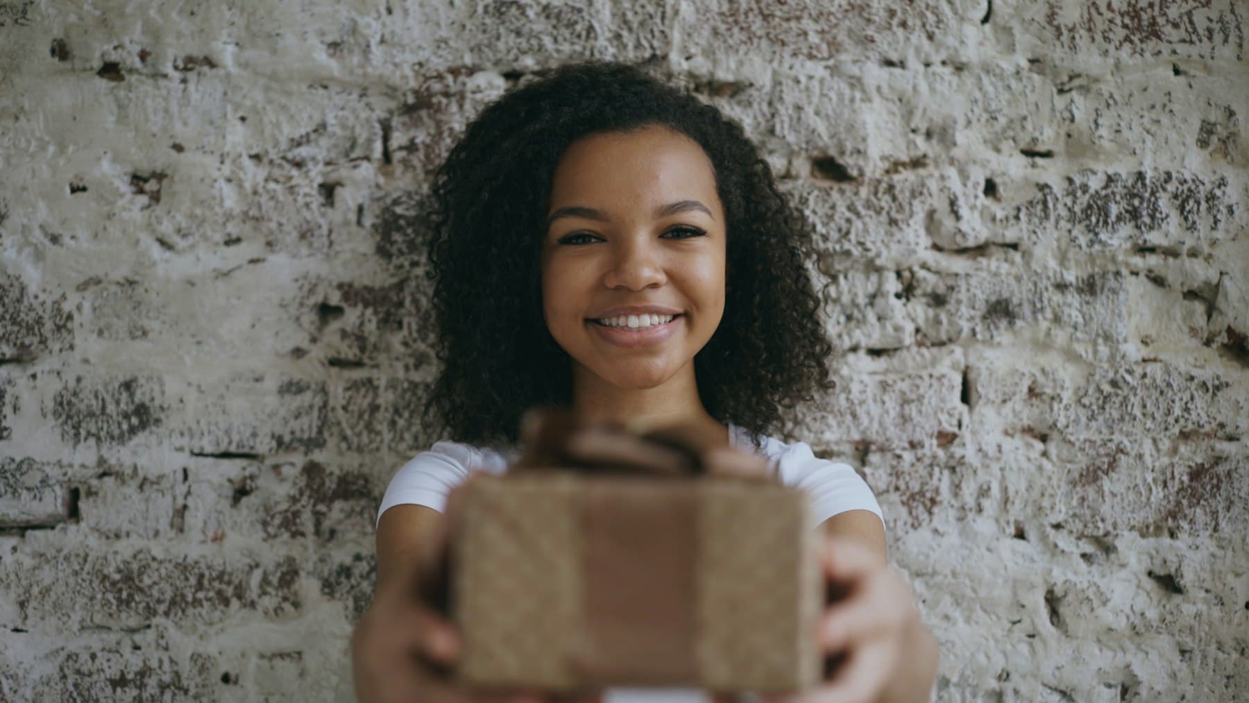 Smiling customer holding out a kraft parcel